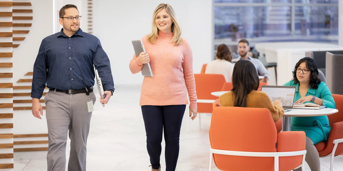 Two employees walking through the office together