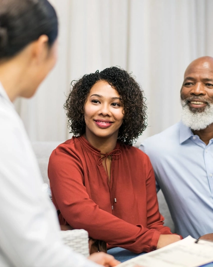 Female doctor speaking with a man and a woman in an office