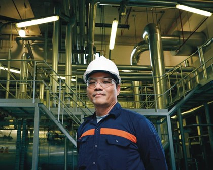 man in hard hat and safety goggles in factory